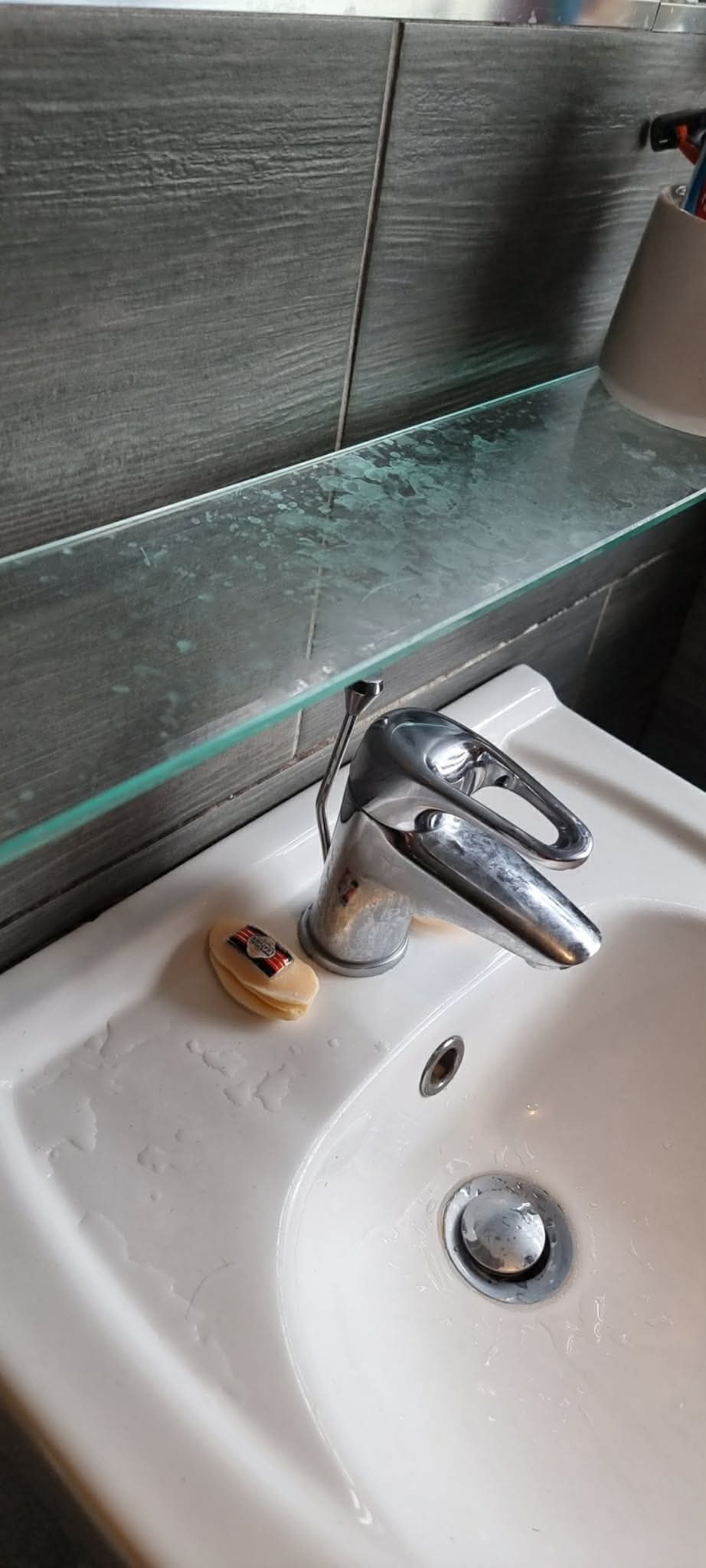 Bathroom basin and glass shelf before cleaning